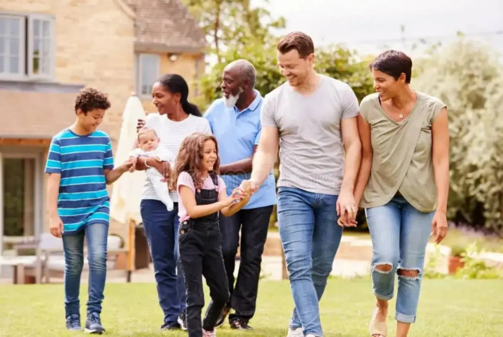 A group of people walking on the grass.